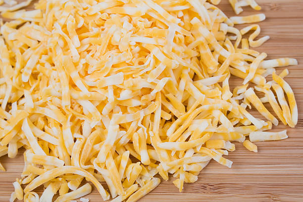 Shredded Colby and Monterey Jack Cheese Shredded Colby and Monterey Jack cheese on a wood cutting board. colby cheddar stock pictures, royalty-free photos & images