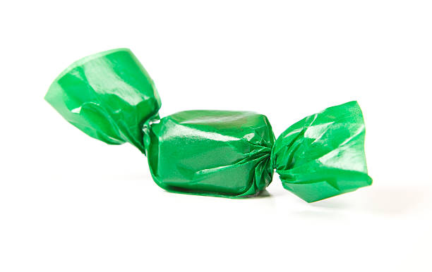 Tasty candy in green wrapper isolated on white