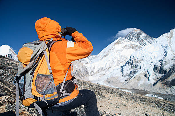 istock Woman lookin through binoculars at Mount Everest 182381369