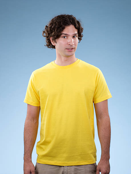 jovem macho vestindo branco camisa amarela - arms at side imagens e fotografias de stock