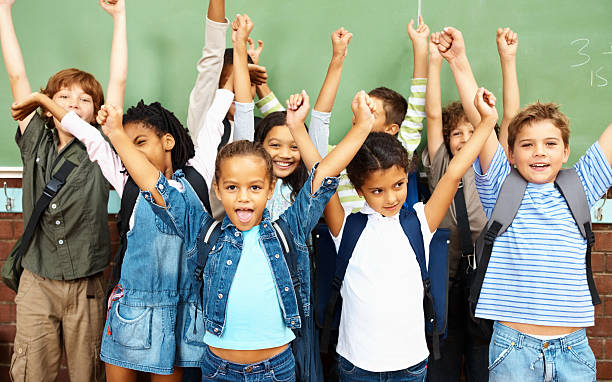 istock Little school children with their hands raised 182382268