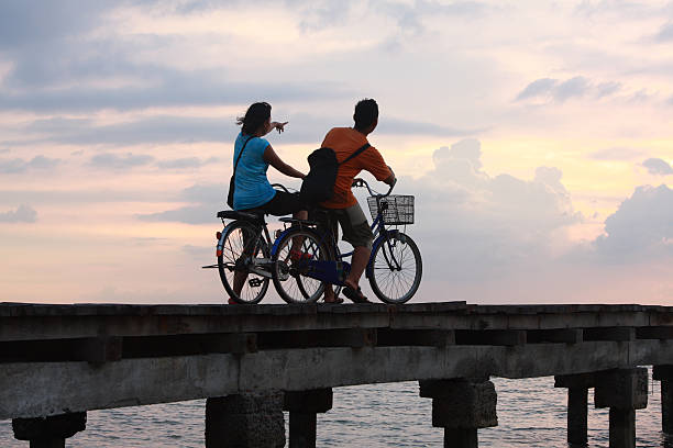 two friends on the bike with sunset