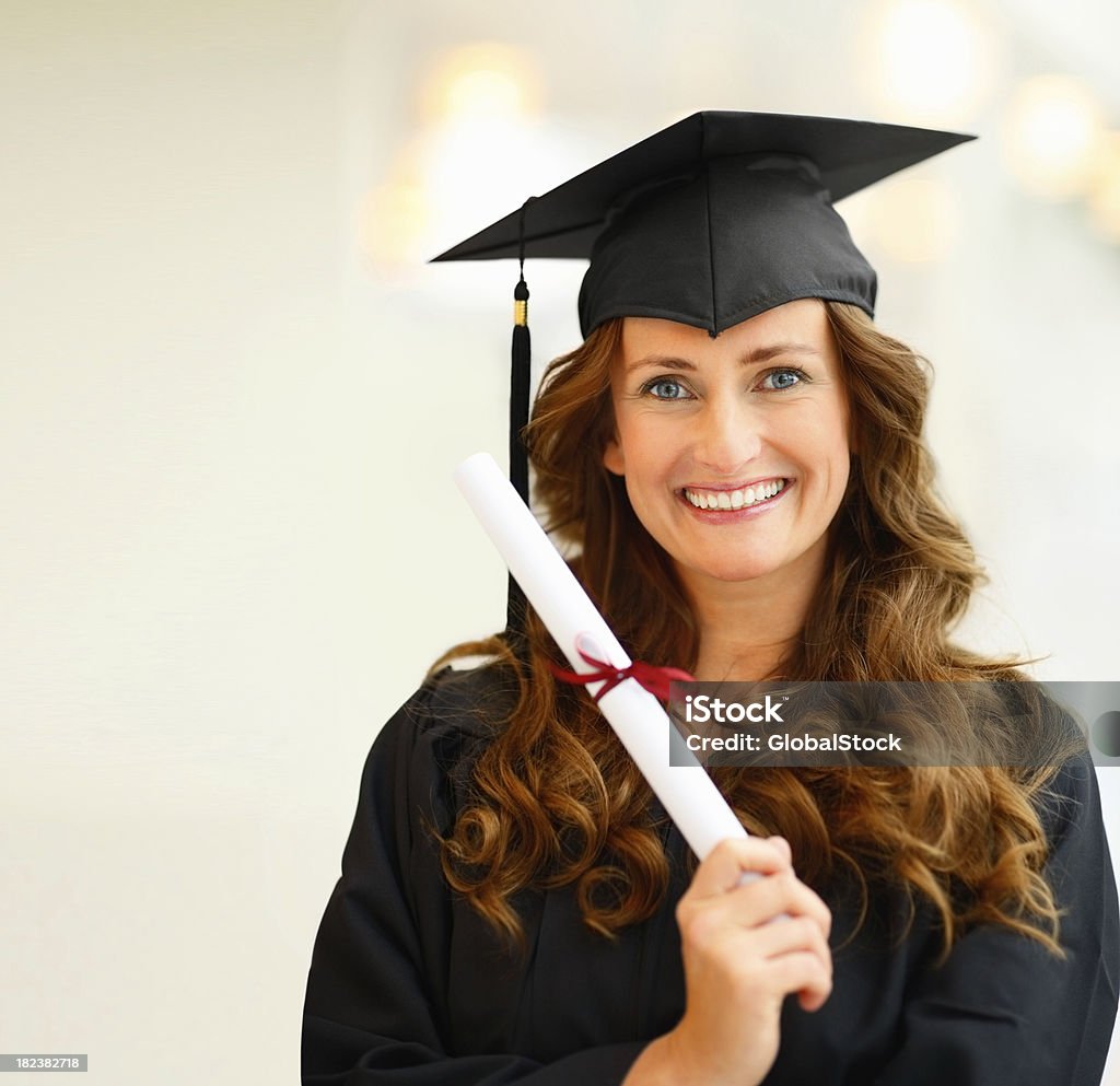 Retrato de uma jovem mulher segurando seu nível de pós-graduação - Foto de stock de 20 Anos royalty-free