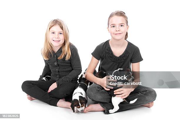 Hermanas Con Beagle Crías Sobre Un Fondo Blanco Foto de stock y más banco de imágenes de Niñas - Niñas, 6-7 años, 8-9 años