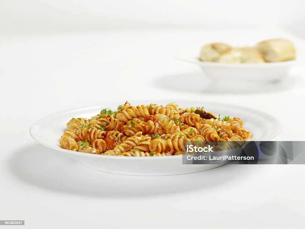 Rotini Pasta in Tomato Sauce Rotini Pasta in Tomato Sauce with Fresh Parsley and French Bread -Photographed on Hasselblad H3D2-39mb Camera Plate Stock Photo