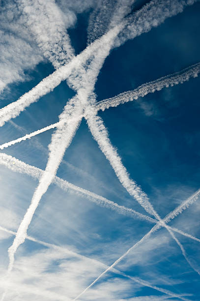 Several vapor trails crossing in the sky Airplane trails background vapor trail photos stock pictures, royalty-free photos & images