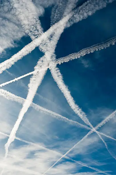 Photo of Several vapor trails crossing in the sky