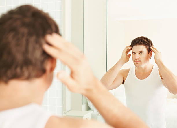 istock Handsome guy looking at self in the mirror 182383179