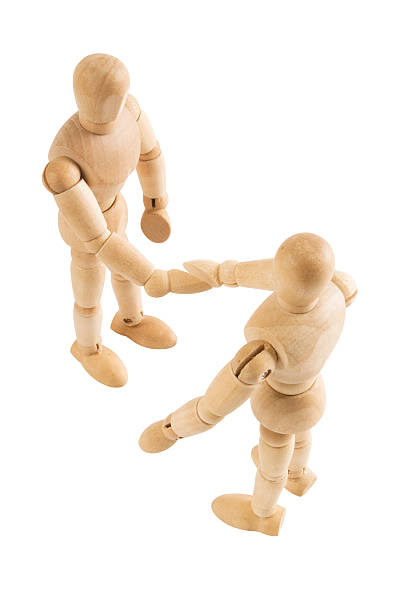 istock Wooden mannequins shaking hands on white background 182383207