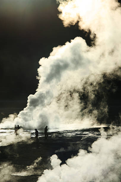 People walking on the El Tatio geyser field at dawn stock photo
