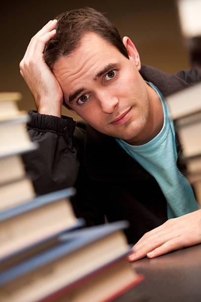 istock Worried Young Student with School Books in the Library 182385217
