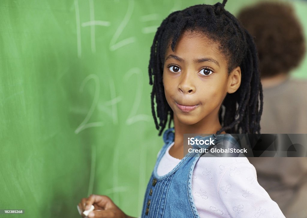 School girl resolver matemáticas sumas en la placa - Foto de stock de Escribir libre de derechos