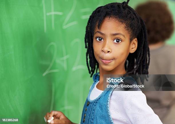 School Girl Resolver Matemáticas Sumas En La Placa Foto de stock y más banco de imágenes de Escribir - Escribir, Niñas, 8-9 años