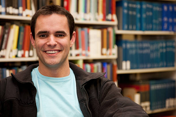istock Happy Young Man Near Books in School Library 182386072
