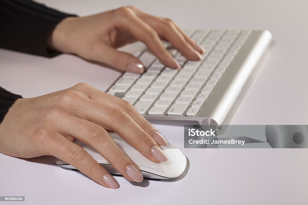 Mani digitando con un bianco essenziale Wireless tastiera del Computer e Mouse - Foto stock royalty-free di Mela
