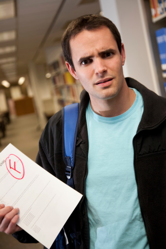Upset College Student in Library Holding F Grade on Exam.See more from this series: