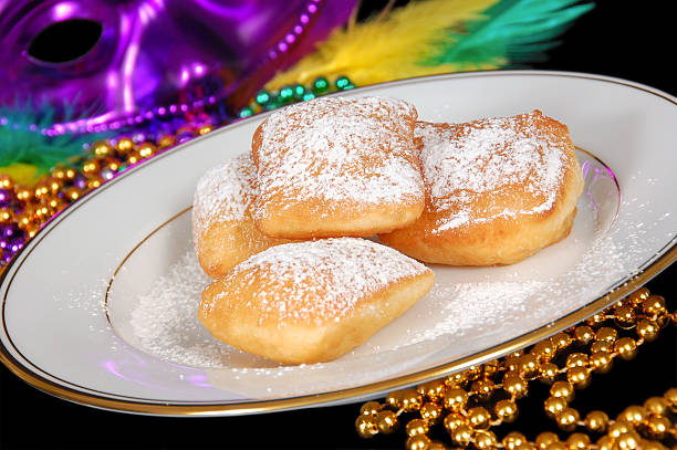 New Orleans Style Beignets A plate of New Orleans style beignets surrounded by traditional symbols of the New Orleans Mardi Gras celebration.More images from this series: beignet stock pictures, royalty-free photos & images