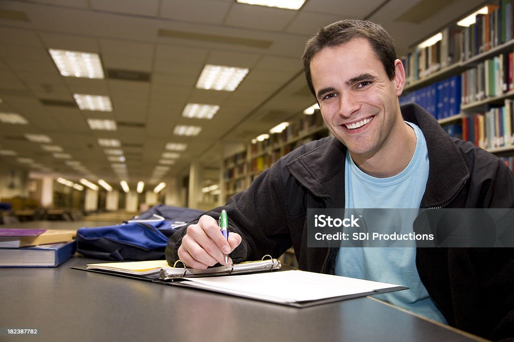 Happy College Student Studying and Writing in Library Happy College Student Studying and Writing in Library.See more from this series: 20-24 Years Stock Photo