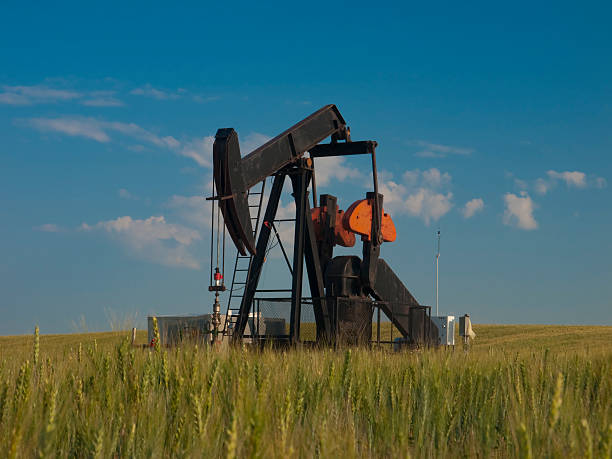 istock Oil Pump Pumpjack With Wheat in Foreground 182389365