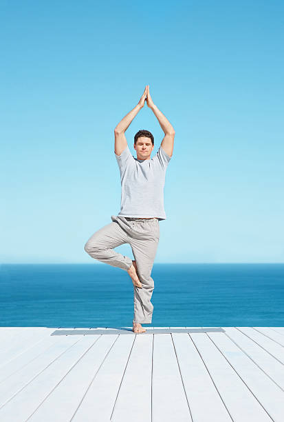 istock Mid adult  man practicing yoga on a porch 182389716