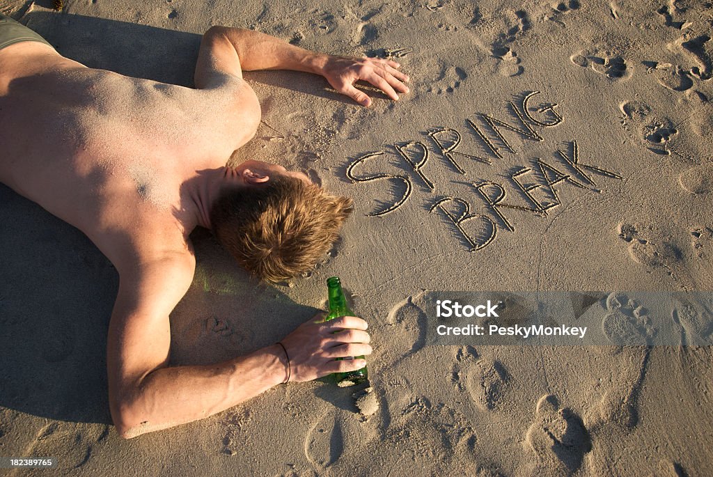 Ubriaco primavera Casualty con bottiglia di birra Sdraiato su un Beach - Foto stock royalty-free di Spiaggia