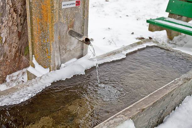 Natural spring of mineral water in winter. A frozen ice-hole with clear, slightly salty water and small stones visible through the clear water. Gifts of nature for health, Solikamsk (Ural, Russia)
