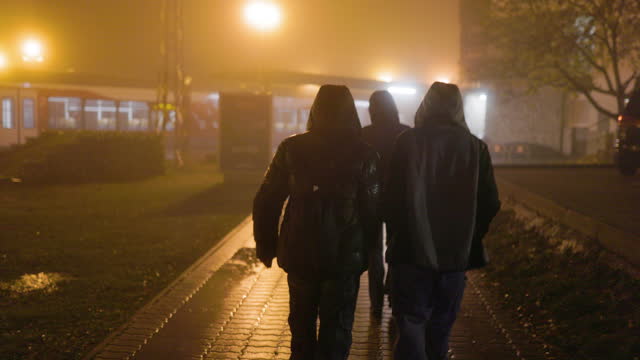 Teenagers walking in the Štrbské Pleso train station on a foggy night