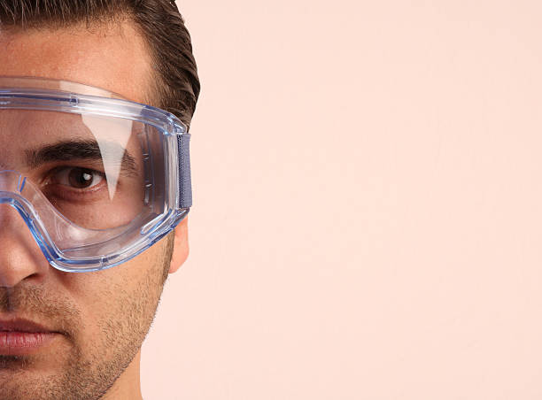 A close-up of a male worker wearing safety glasses stock photo