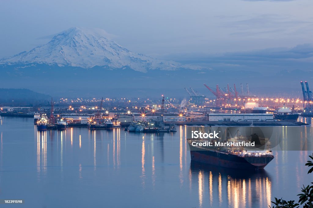 A photo of port Tacoma and a snow topped Mount Rainier Port of Tacoma With Mount Rainier In Background at dusk Washington State Stock Photo