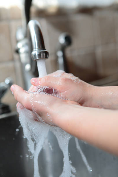 istock Child's hands washing in kitchen sink 182392085