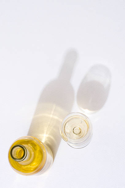 Overhead view of wine bottle and glass with their shadows Overhead shot of white wine on tablecloth. white wine photos stock pictures, royalty-free photos & images