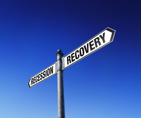 Low-angle view of signpost showing two opposite directions - recession and recovery.Clipping path included for easy background change.