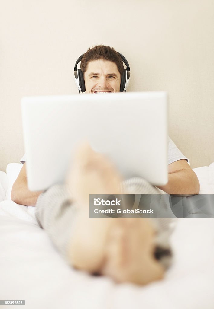 Heureux homme écoute de la musique tout en utilisant un ordinateur portable - Photo de 35-39 ans libre de droits
