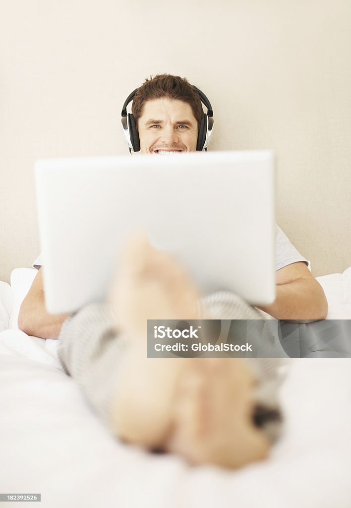 Homem feliz ouvir música enquanto estiver usando o laptop - Foto de stock de 30 Anos royalty-free