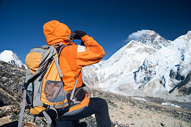 istock Woman looking through binoculars at Mount Everest 182394628