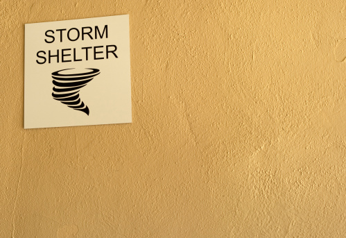 A storm shelter sign on a basement wall of a public building in the American Midwest.