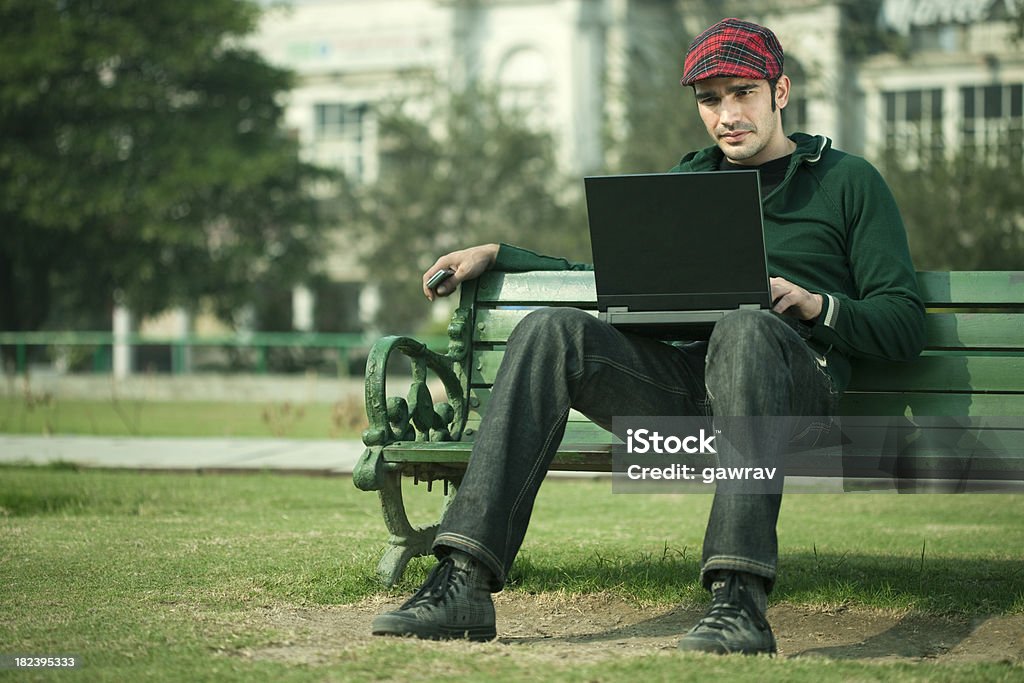 ゆったりした、自信を持った若い男性の読書、ノートパソコンの画面 - 1人のロイヤリティフリーストックフォト