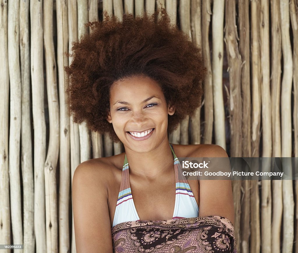 Afro-americana mulher sorrindo contra a parede de bambu - Foto de stock de 20 Anos royalty-free