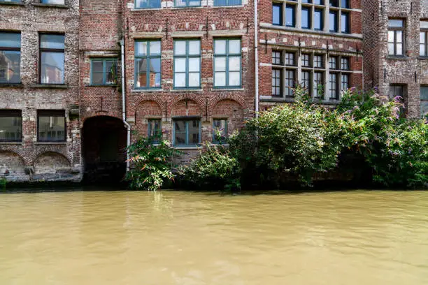 Photo of Close up view of red brick house just near Lys river. Ghent, Belgium