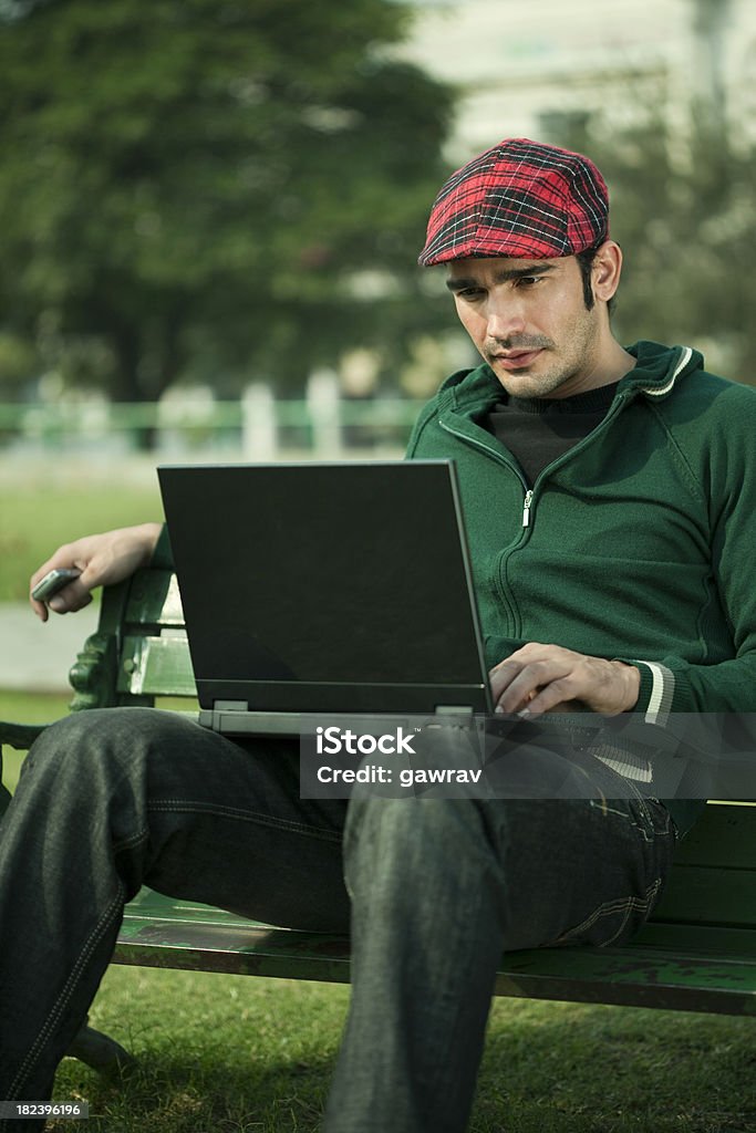 Rilassato fiducioso giovane uomo leggere su un computer portatile schermo - Foto stock royalty-free di 25-29 anni