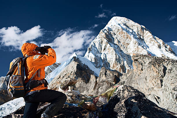 istock Woman looking through binoculars at Pumori 182396660