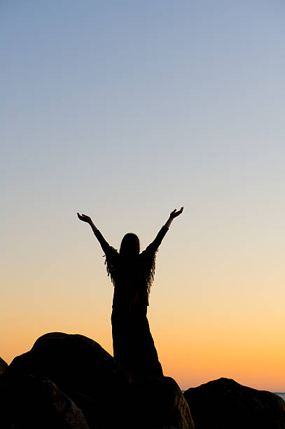 istock Woman raising her hands towards the sunset sky 182396697