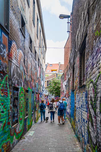 Pedestrians walk past a row of street art on the famous Hosier Lane in downtown Melbourne, Victoria, Australia on an overcast day.