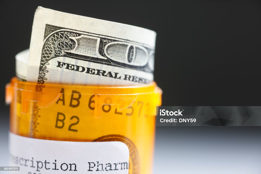 Health Care Costs A one hundred dollar bill rolled in a prescription bottle.To see more of my medical images click on the link below Currency Stock Photo