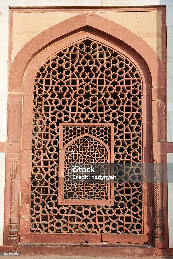 Marble screen window in Humayun's Tomb Humayun's tomb is a complex of buildings built as the Mughal Emperor Humayun's tomb, commissioned by Humayun's wife Hamida Banu Begum in 1562 CE, and designed by Mirak Mirza Ghiyath, a Persian architect.It was the first garden-tomb on  the Indian subcontinent, and is located in Nizamuddin East, Delhi, India, close to the Dina-panah nothing also known as Purana Qila, that Humayun founded in 1533. It was also the first structure to use red sandstone at such a scale. The  complex was declared a UNESCO World Heritage Site in 1993. Abstract Stock Photo