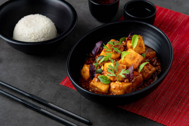 istock Mapo Tofu bowl with side sauces on black stone table 1823982544