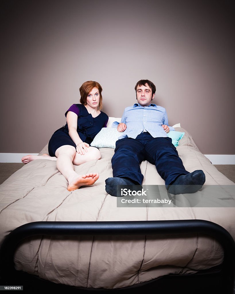 Bedroom Boredom Young couple lying on their bed, side by side, looking bored.  Bed - Furniture Stock Photo