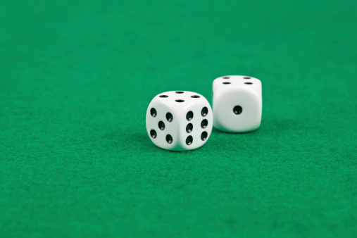 Two dices on green felt.