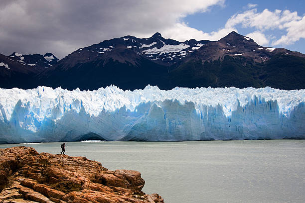 mann zu fuß in der vorderseite des perito moreno-gletscher - serac stock-fotos und bilder