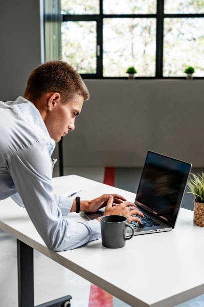 istock Serious concentrated young entrepreneur working in office on laptop 1823988337